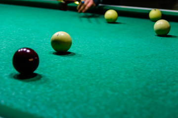 Player arm with the cue and balls on the green cloth. Russian billiard