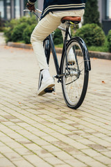 low section view of stylish man riding bicycle in city
