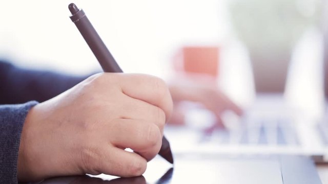 female designer working on laptop with a graphic tablet