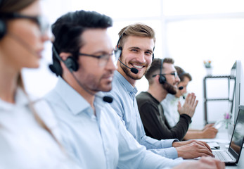 handsome male customer support phone operator with headset working in call center