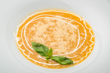 Pumpkin and carrot soup with cream and parsley on dark wooden background Top view