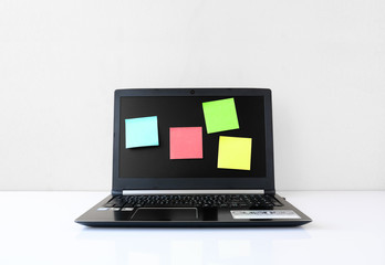 Laptop on desks with Sticky Notes  In the office of a businessman