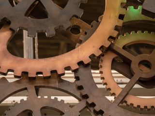 Low angle view to part of cogwheels. Vintage iron machine part in store. Abstract background of old industrial.