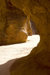Light highlights the path through the Siq to the ancient city, Petra, Jordan.