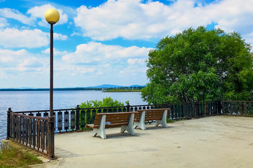 Promenade with benches ovelooking the lake, mountains and beautiful sky