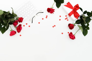 Flat lay, top view Valentine's day women's office desk. Female workspace with laptop,  flowers red roses,  accessories, glasses, gift on white  background. Top view feminine background.Copy space