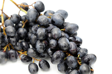 Details of black grapes on white background.