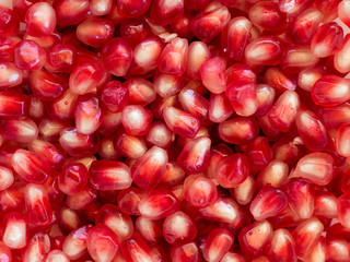 Red Background of Grain Red Grenades. Big Ripe Red Granets or Garnets. Fruits of Red Ripe Pomegranate on the White Background. Vegetarian Concept, Organic Vitamins. Organic and Benefit Garnet Fruit.
