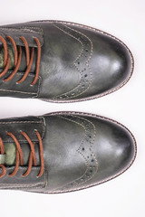 A pair of khaki color oxford man shoes with red shoelaced on white  background. Fashion footwear. Brogues. Burgundy color