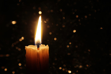 Candles Burning at Night. White Candles Burning in the Dark with focus on single candle in...