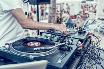 Beach party - dj's hands and turntable with records