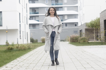 Junge Frau läuft in einer modernen Wohnanlage