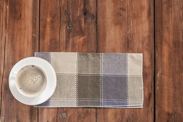 White cup of coffee on vintage wood. Top view.