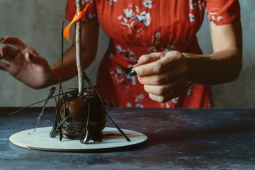 Woman decorating halloween apples with crystallized caramel.