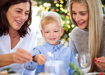 A small boy with mother and grandmother holding sparkle at Christmas time.