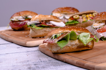 Mixed salad sandwiches with integral bread on wooden board