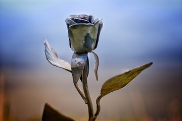 view of an abstract metallic rose in the midst of a field, close-up