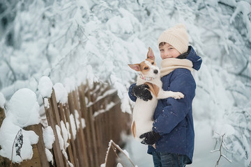 Boy in the winter forest is holding a puppy Jack Russell Terrier - 227327462