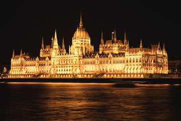 Fototapeta na wymiar Palast Gebäude mit Turm und Kuppel beleuchtet bei Nacht am Fluss Ufer Wasser