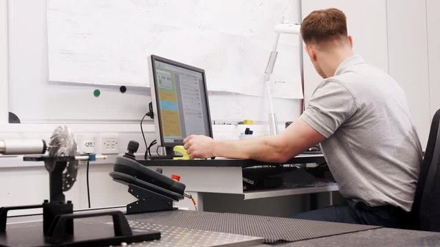 Male Engineer Uses CMM Coordinate Measuring Machine In Factory