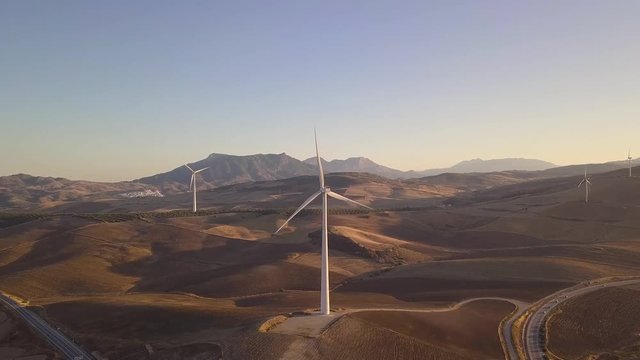 Aerial view of Wind Turbines generating clean energy at Sunset 