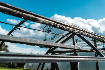 Close up of old greenhouse with blue skies and clouds