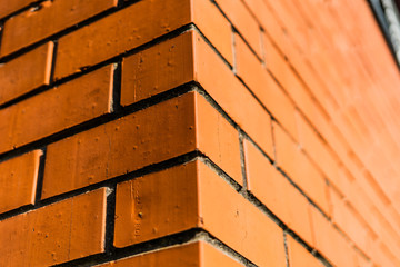 Close up edge of orange brick house with shallow depth of field