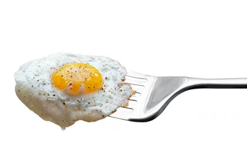 Foto op Plexiglas Spiegeleieren Single gebakken ei besprenkeld met gemalen zwarte peper rustend op metalen spatel geïsoleerd op wit.