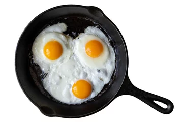 Photo sur Aluminium Oeufs sur le plat Trois œufs au plat dans une poêle à frire en fonte isolés sur blanc d& 39 en haut.