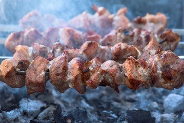 Meat grilling on charcoal and flame