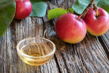 A bowl of apple cider vinegar with fresh apples
