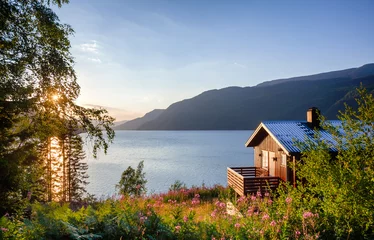 Tuinposter Wooden summerhouse with terrace overlooking scenic lake at sunset in Norway Scandinavia © Dmitry Naumov