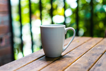 White mug on a wooden table outside