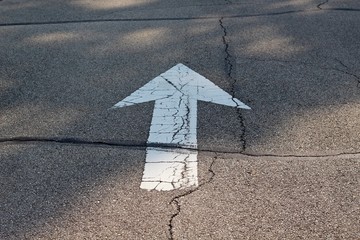 A white arrow pointing straight ahead on the road.