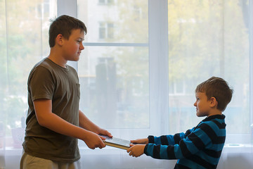 Two schoolchildren quarrel and fight with books