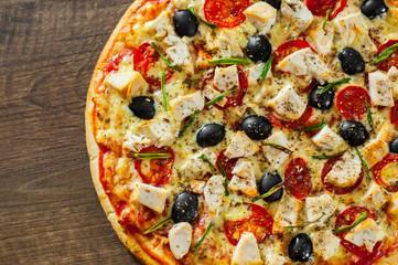 Pizza with Chicken meat, Mozzarella cheese, tomato, olive. Italian pizza on wooden background