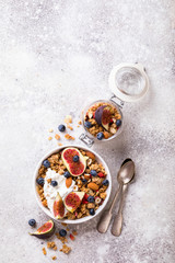 Muesli with Nuts Yogurt and fresh Figs Blueberry on the gray Background.Granola Healthy Breakfast. Sweet food Dessert. Snack  Dry Diet Nutrition Concept.Top View. Flat Lay.Copy space for Text