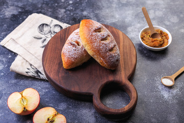 Homemade little apple cakes on round wooden plate, serving icing sugar