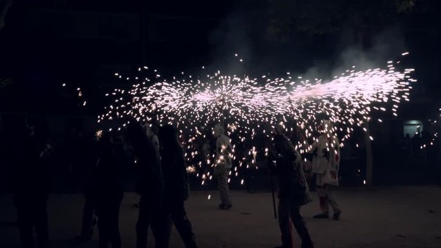 Traditional correfoc performance. In the correfoc, a group of individuals will dress as devils or Diables and light fireworks - fixed on devil's pitchforks or strung above the route