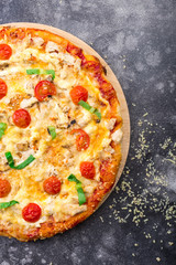 Pizza with chicken and tomatoes on a grey background. space for text