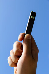 Boy hand holding JUUL ecigarette