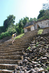 climbing the stairs of palenque ruins in mexico