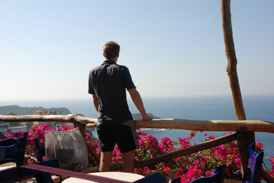 Young Man Looking Out Over The Ocean In Acapulco