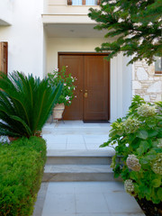 Athens Greece, contemporary house entrance wooden door with foliage and stairs