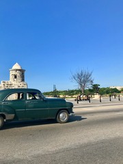 Asphalt streets with a beautiful historic classic retro vintage car as a form of transportation in the scenic modern part of Havana (La Habana), the capital of the beautiful Caribbean island of Cuba