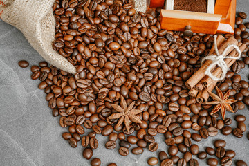 Cup of coffee with steam, coffee beans, chocolate pieces, cinnamon sticks, white and brown sugar,...