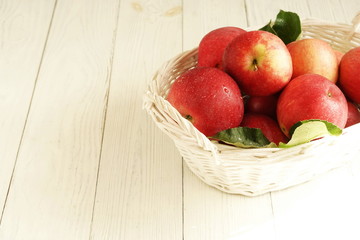 red apples in a basket on white vintage background. top view. copy space