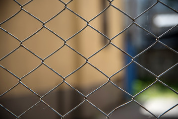 Closeup of a gray steel mesh fence with a blurred background. metal fence and space protection. mesh diamond