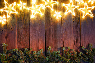 Christmas glowing stars and fir on wood