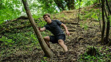 Naklejka na ściany i meble the guy is running down a steep hill while participating in an ocr race